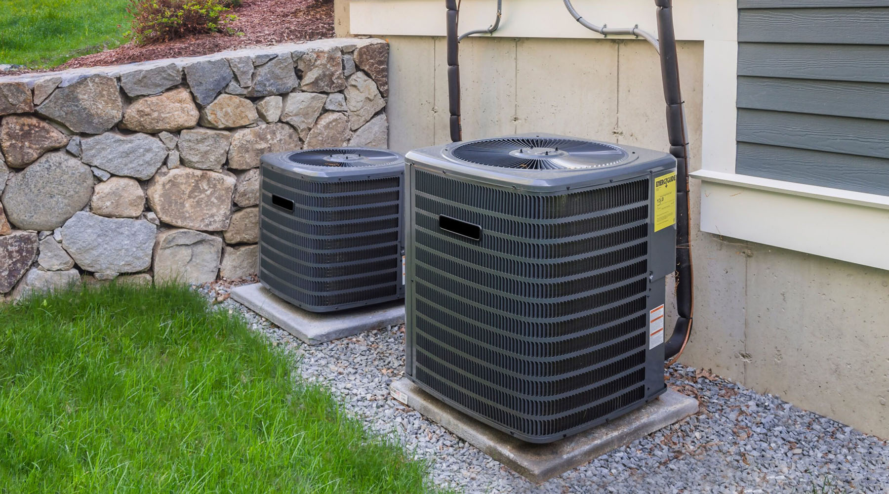 two HVAC condensers in backyard